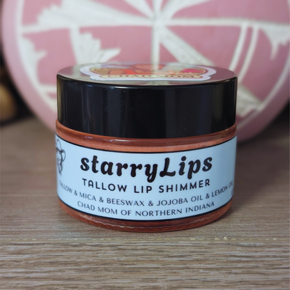 Jar of starryLips tallow lip shimmer on a wooden surface with a blurred background