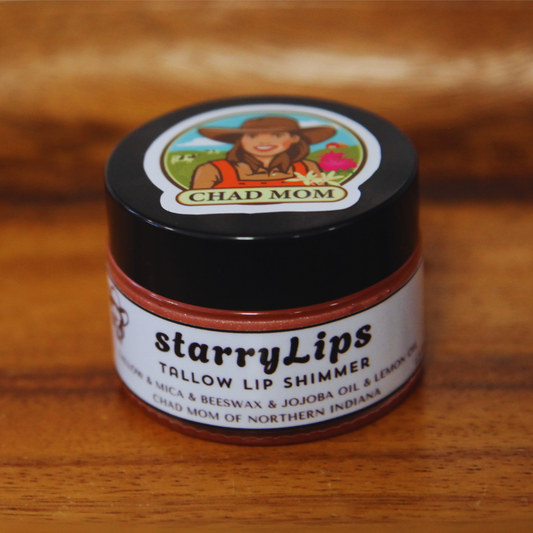 Jar of starryLIPS tallow lip shimmer on a wooden surface